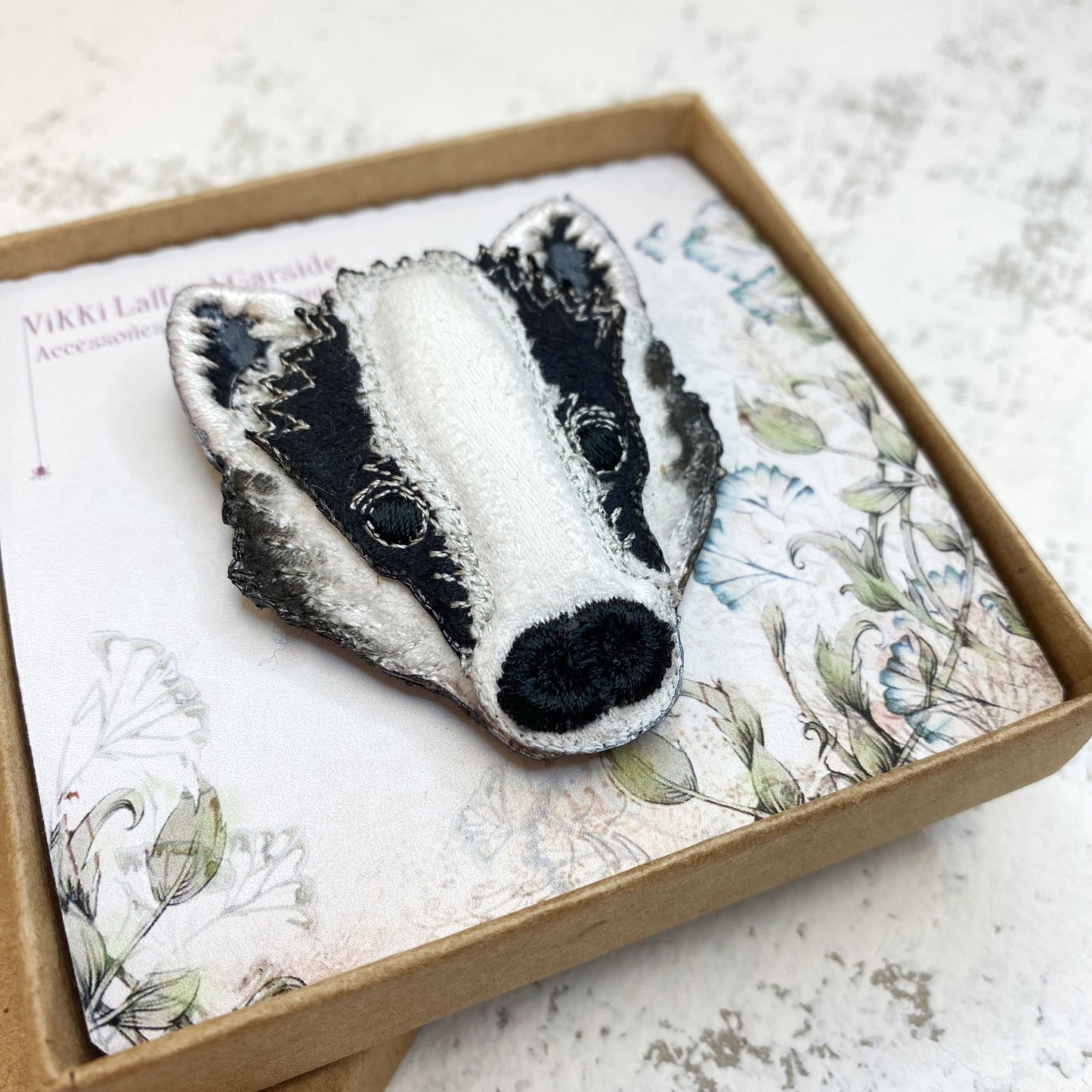 Embroidered and painted fabric badger brooch