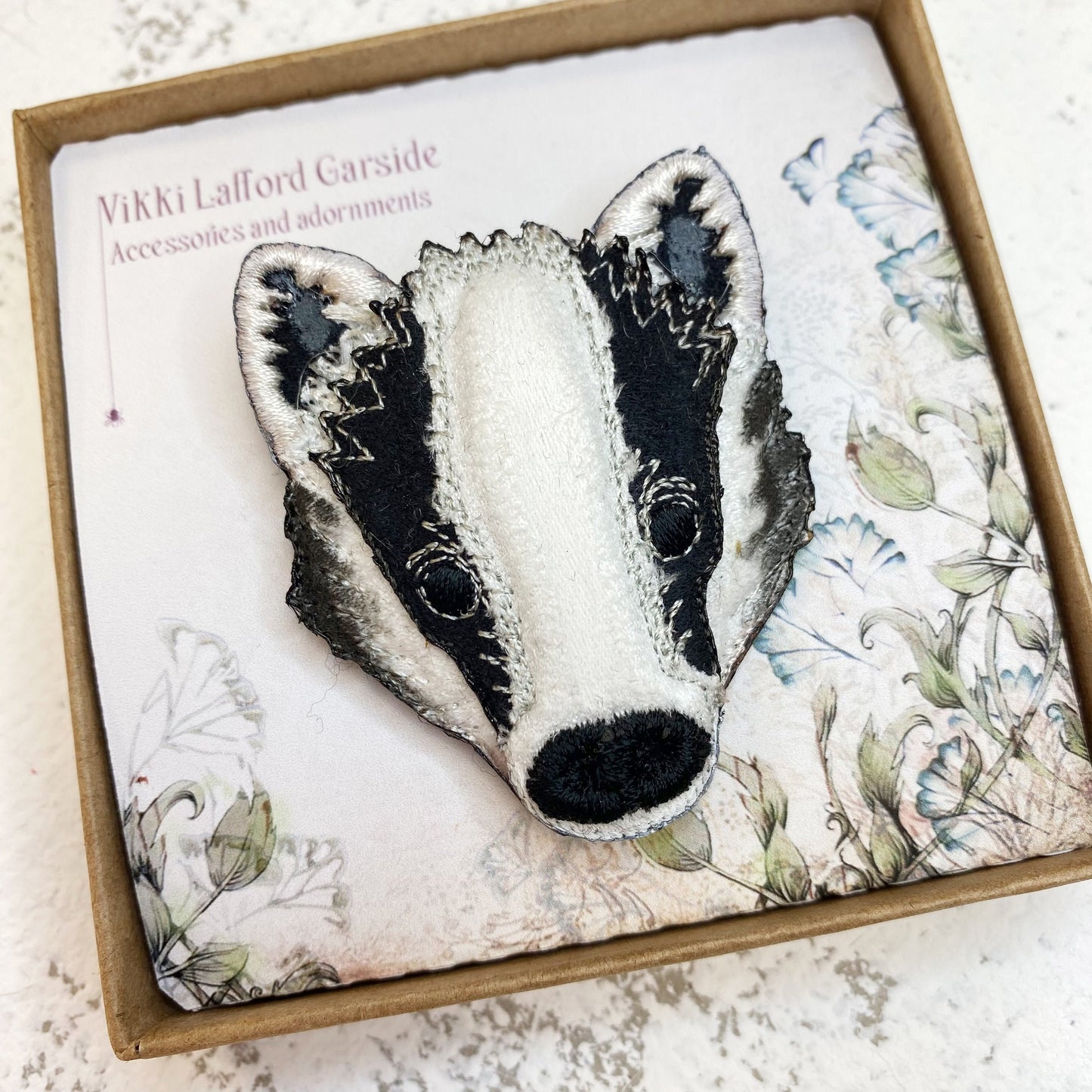 Embroidered and painted fabric badger brooch