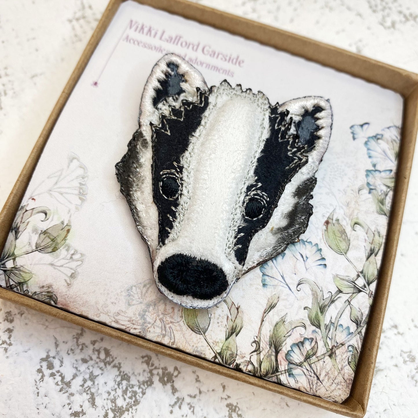 Embroidered and painted fabric badger brooch
