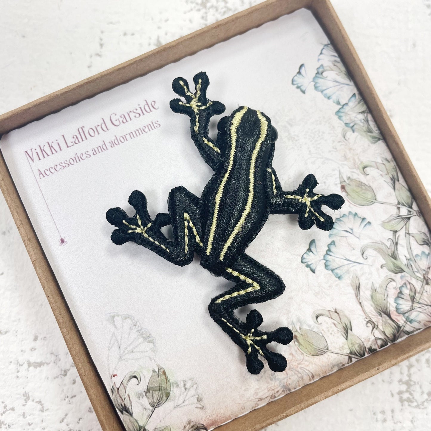 Handcrafted black and yellow striped frog brooch