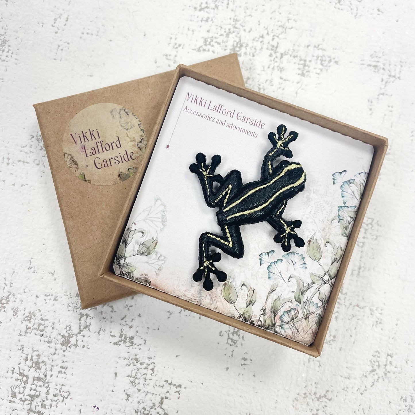 Handcrafted black and yellow striped frog brooch