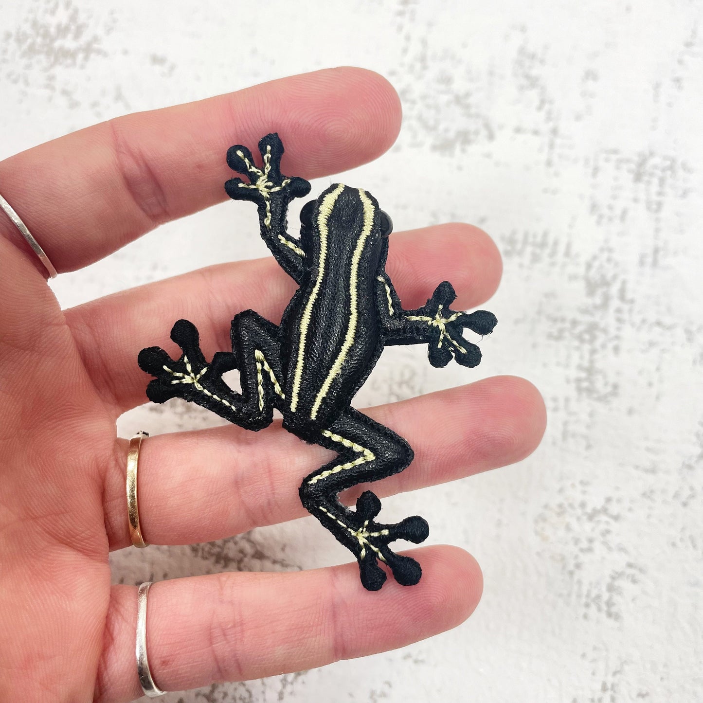Handcrafted black and yellow striped frog brooch