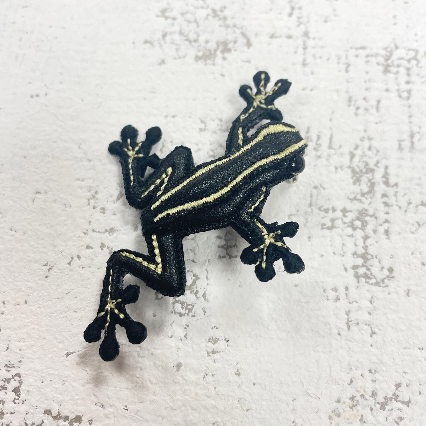 Handcrafted black and yellow striped frog brooch